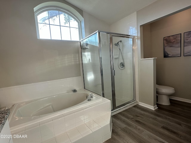 bathroom featuring hardwood / wood-style flooring, plus walk in shower, and toilet