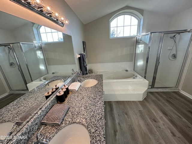 bathroom featuring a healthy amount of sunlight, vanity, shower with separate bathtub, and vaulted ceiling