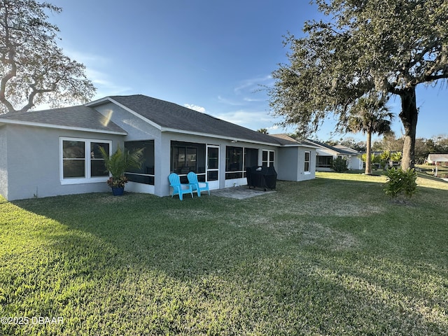 rear view of property with a yard and a sunroom