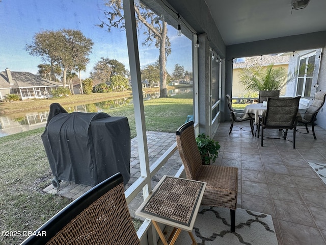 sunroom featuring a water view