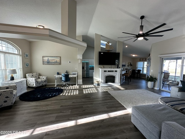 living room with ceiling fan, dark hardwood / wood-style floors, and vaulted ceiling