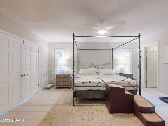 bedroom with light tile patterned floors, a textured ceiling, and ceiling fan