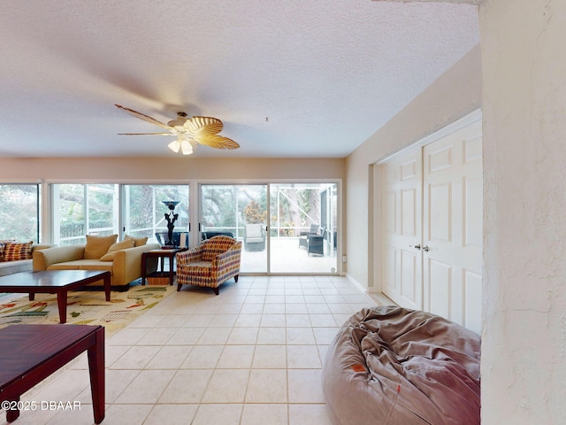 living room featuring light tile patterned floors, a textured ceiling, and ceiling fan