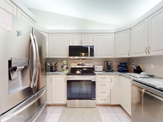 kitchen with light tile patterned floors, light stone countertops, white cabinets, and appliances with stainless steel finishes