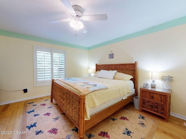 bedroom with light hardwood / wood-style floors and ceiling fan