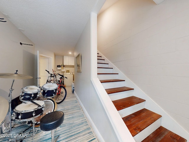 staircase with a textured ceiling