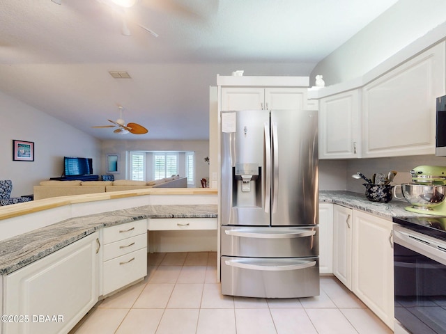 kitchen with white cabinetry, appliances with stainless steel finishes, light stone counters, and light tile patterned floors