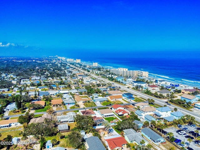 birds eye view of property featuring a water view and a beach view