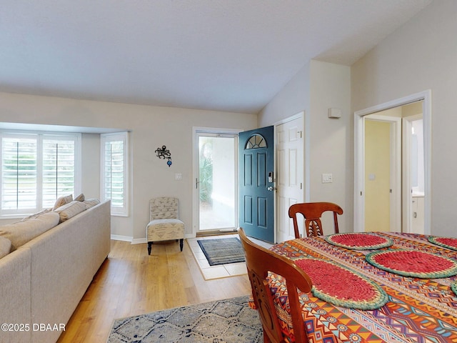 dining room with lofted ceiling and light wood-type flooring