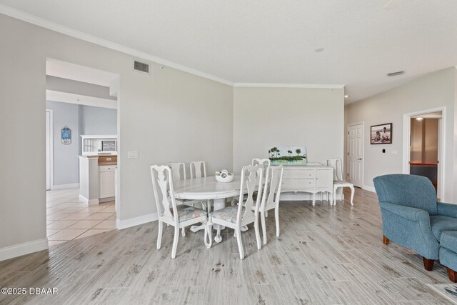 4650 Links Village Dr Unit B103, Ponce Inlet, FL 32127 - dining area featuring light wood-style floors and crown molding