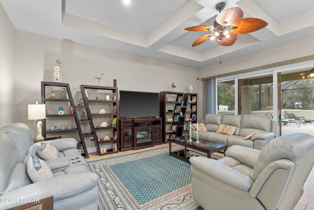 living room with ceiling fan and a tray ceiling