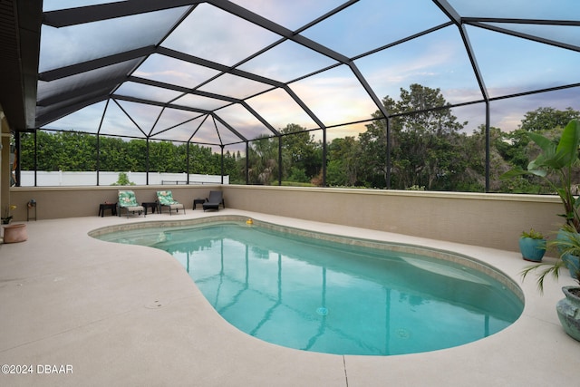 view of swimming pool featuring a lanai and a patio