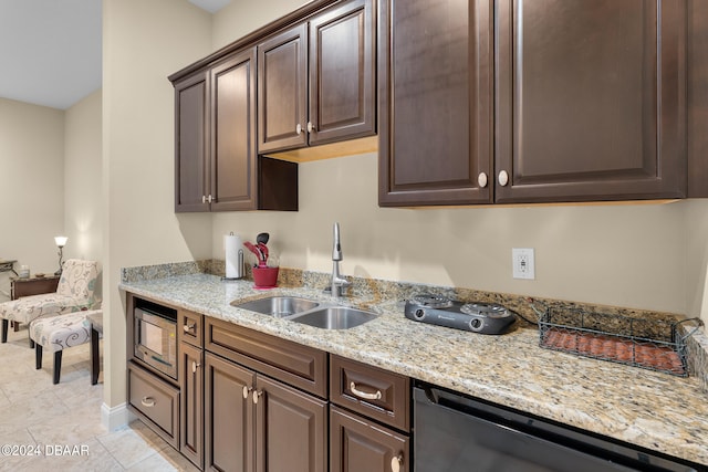 kitchen featuring sink, light tile patterned floors, appliances with stainless steel finishes, dark brown cabinets, and light stone counters