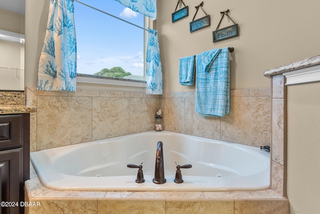 bathroom with vanity and tiled bath