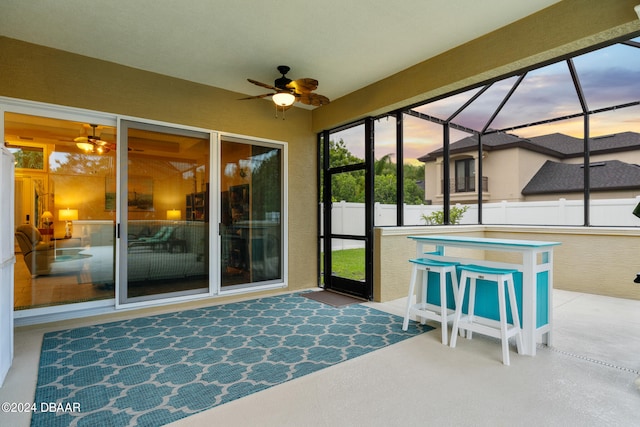 unfurnished sunroom featuring ceiling fan