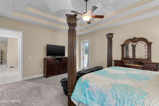 bedroom featuring a raised ceiling, ceiling fan, and light colored carpet