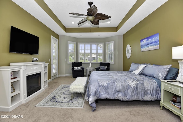 786 Jollymon Way, Daytona Beach, FL 32124 - carpeted bedroom with a raised ceiling, a ceiling fan, a glass covered fireplace, baseboards, and recessed lighting