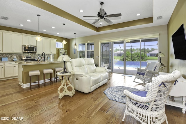 786 Jollymon Way, Daytona Beach, FL 32124 - living room with a raised ceiling, healthy amount of natural light, a ceiling fan, wood finished floors, and recessed lighting