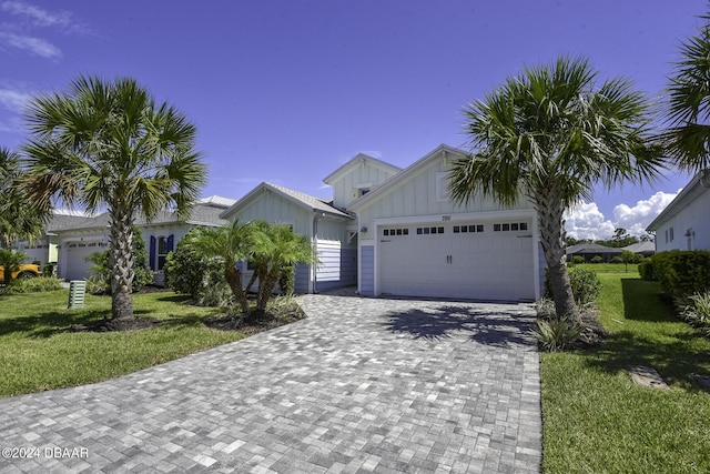 786 Jollymon Way, Daytona Beach, FL 32124 - ranch-style home featuring board and batten siding, an attached garage, a front lawn, and decorative driveway