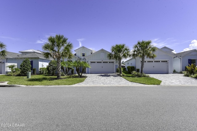 786 Jollymon Way, Daytona Beach, FL 32124 - view of front facade with decorative driveway, a front lawn, an attached garage, and board and batten siding