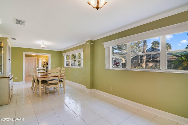 tiled dining space featuring crown molding