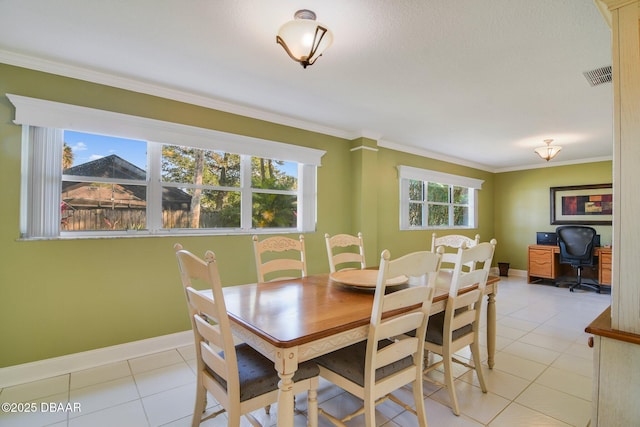 dining space with ornamental molding and light tile patterned floors