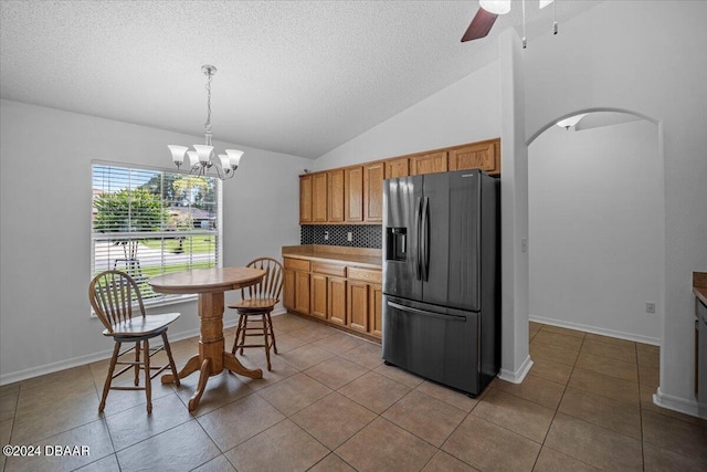 kitchen with backsplash, stainless steel fridge with ice dispenser, hanging light fixtures, tile patterned flooring, and ceiling fan with notable chandelier