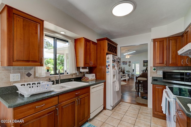 kitchen with light hardwood / wood-style floors, sink, ceiling fan, white appliances, and vaulted ceiling