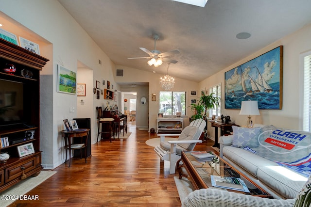 living room featuring wood-type flooring, ceiling fan with notable chandelier, and lofted ceiling