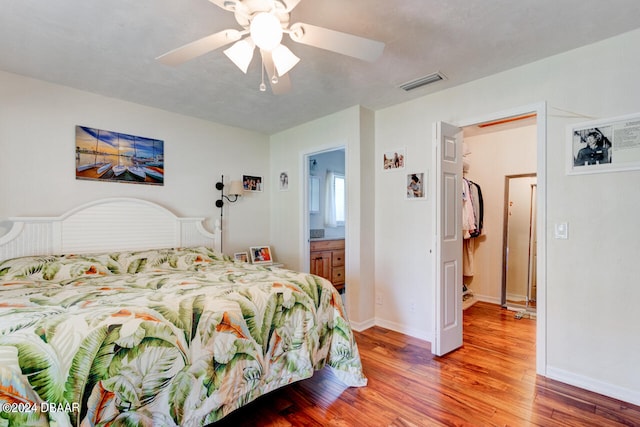 bedroom featuring hardwood / wood-style flooring, ceiling fan, and connected bathroom