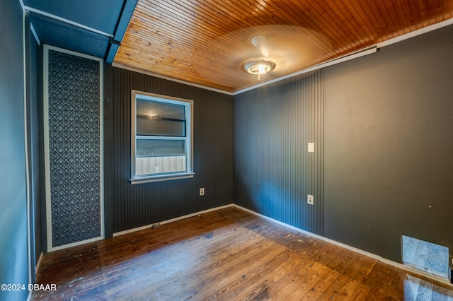 spare room featuring wood ceiling, hardwood / wood-style floors, and crown molding