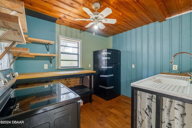 kitchen featuring black fridge, wood-type flooring, stainless steel range with electric stovetop, and wooden ceiling