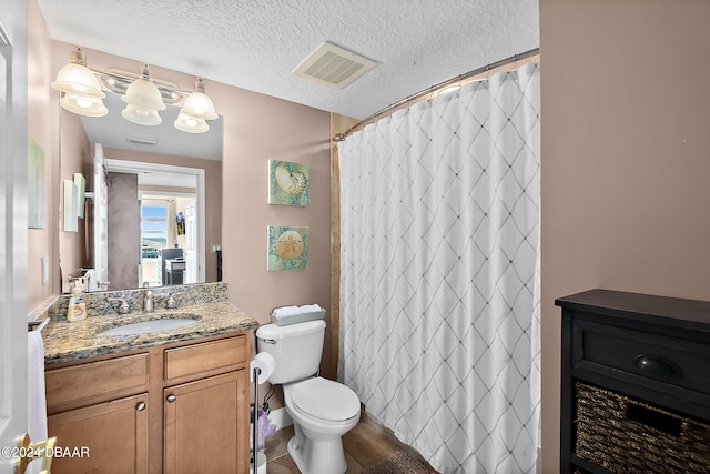 bathroom with a shower with curtain, vanity, a textured ceiling, tile patterned flooring, and toilet