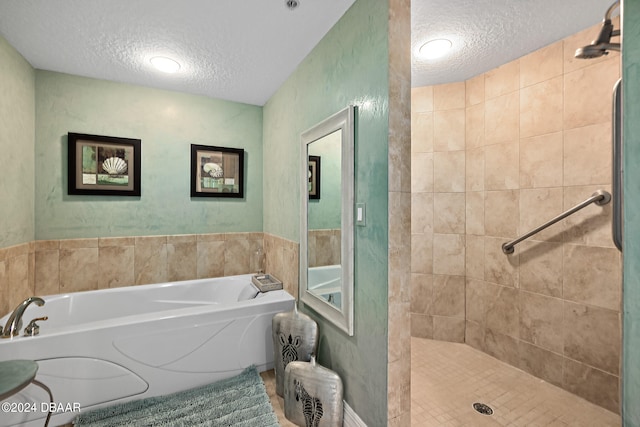 bathroom with shower with separate bathtub and a textured ceiling