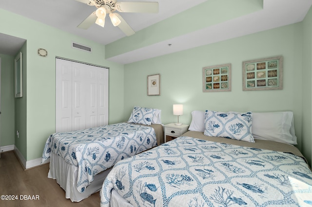 bedroom with hardwood / wood-style floors, ceiling fan, and a closet