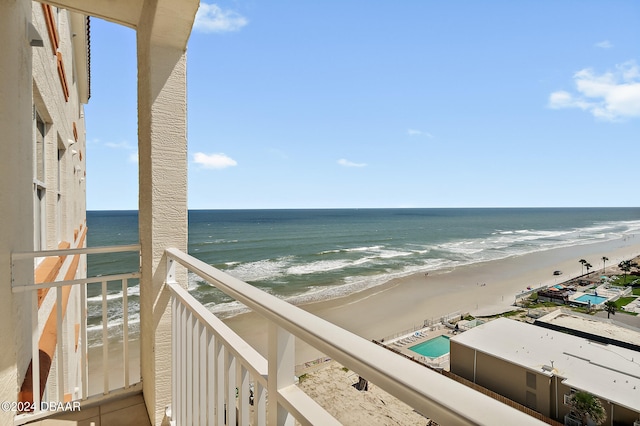 balcony featuring a view of the beach and a water view