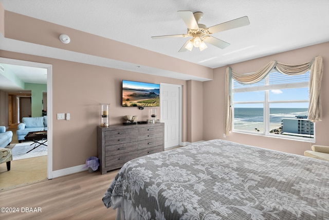 bedroom featuring light wood-type flooring, cooling unit, and ceiling fan