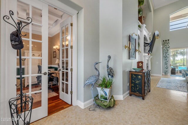 100 Emerald Lake Dr, Palm Coast, FL 32137 - corridor with french doors, a towering ceiling, ornamental molding, baseboards, and tile patterned flooring
