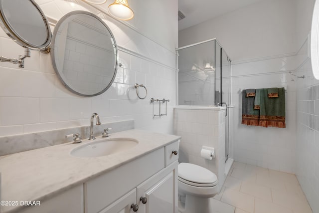 100 Emerald Lake Dr, Palm Coast, FL 32137 - bathroom featuring toilet, vanity, tile walls, a shower stall, and tile patterned floors