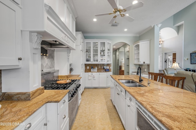 100 Emerald Lake Dr, Palm Coast, FL 32137 - kitchen featuring stainless steel range with gas stovetop, a sink, premium range hood, glass insert cabinets, and decorative backsplash