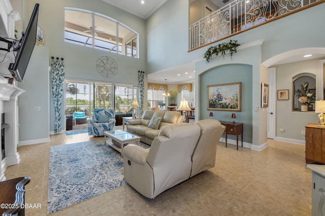 100 Emerald Lake Dr, Palm Coast, FL 32137 - living room with arched walkways, crown molding, baseboards, a towering ceiling, and light tile patterned floors