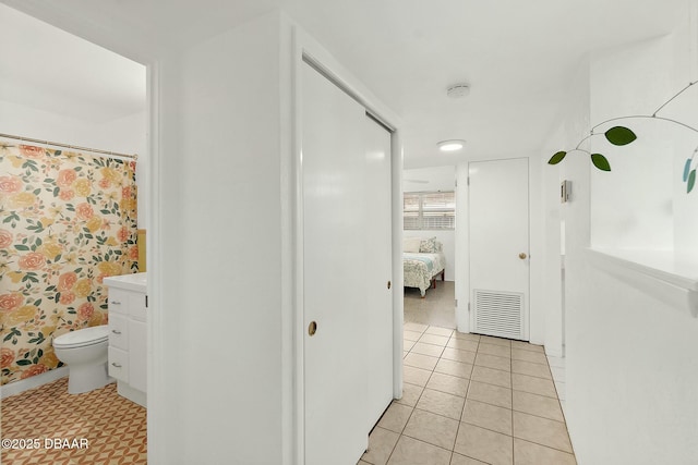 bathroom featuring walk in shower, tile patterned floors, vanity, and toilet