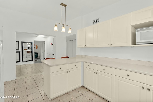 kitchen with pendant lighting, white cabinetry, kitchen peninsula, and light tile patterned floors