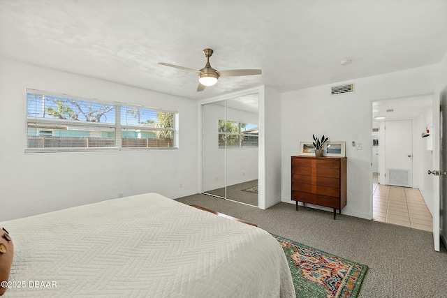 bedroom with ceiling fan, carpet floors, and a closet