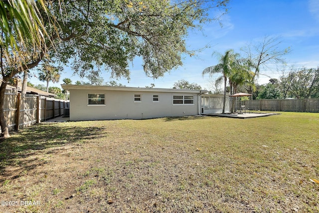 rear view of house with a patio area and a lawn