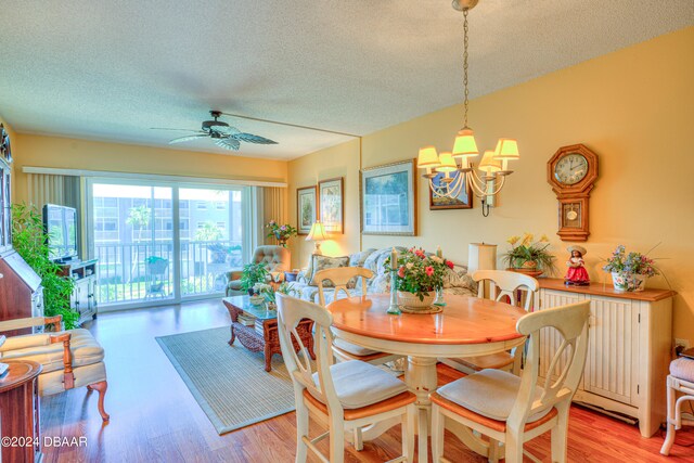 dining space featuring a textured ceiling, ceiling fan with notable chandelier, and light hardwood / wood-style flooring