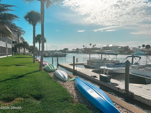 dock area with a yard and a water view