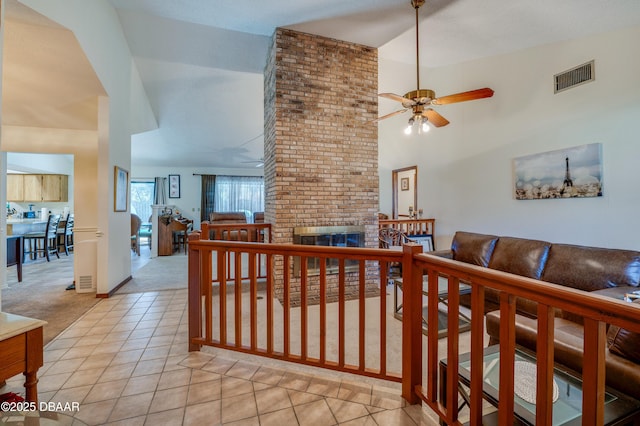 hall featuring light tile patterned floors and high vaulted ceiling