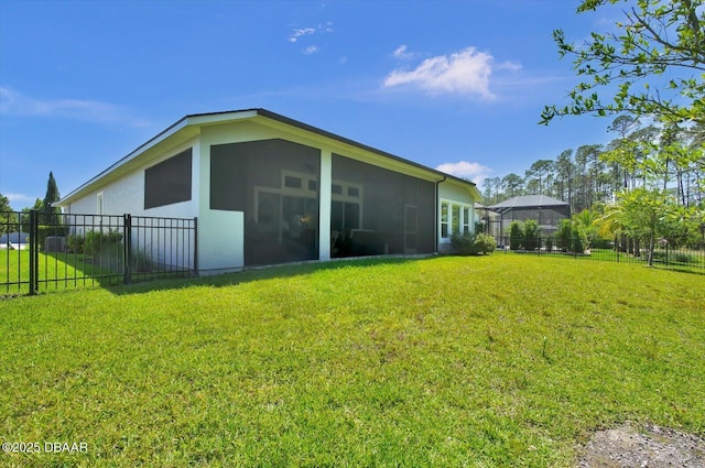 exterior space featuring fence, a yard, and a sunroom