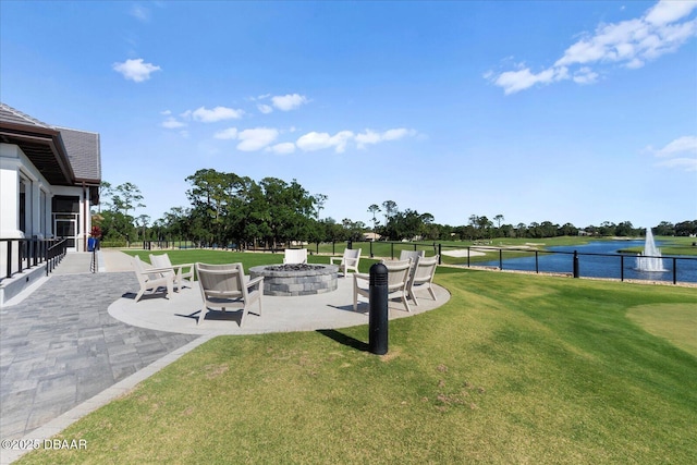 view of yard with view of golf course, a water view, a fire pit, and a patio area